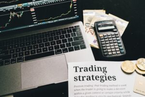 Trading strategies document sat next to a laptop and calculator