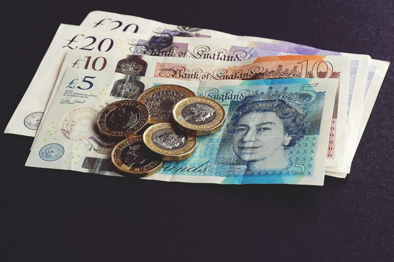 Cash - some bank notes with pound coins on top